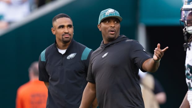 Philadelphia Eagles offensive coordinator Brian Johnson talks with Jalen Hurts before a game against the Cleveland Browns at Lincoln Financial Field.